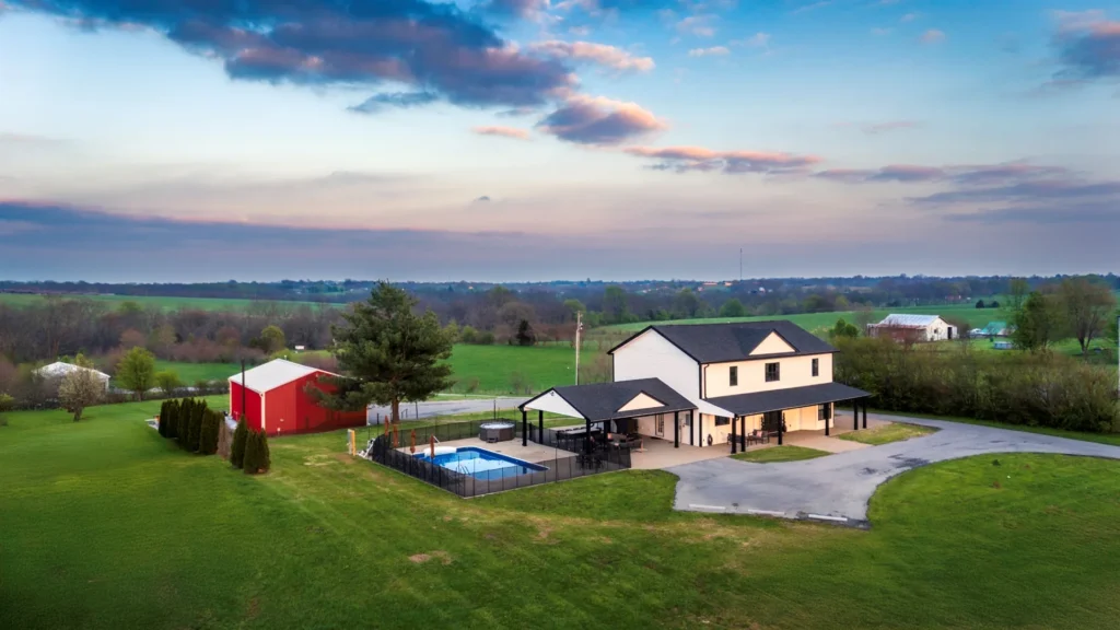 The Farmhouse, separate Game Barn, pool, and Kentucky countryside at sunset