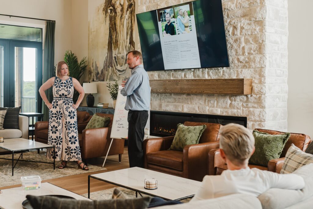 Speakers Talking in front of a large TV and Whiteboard
