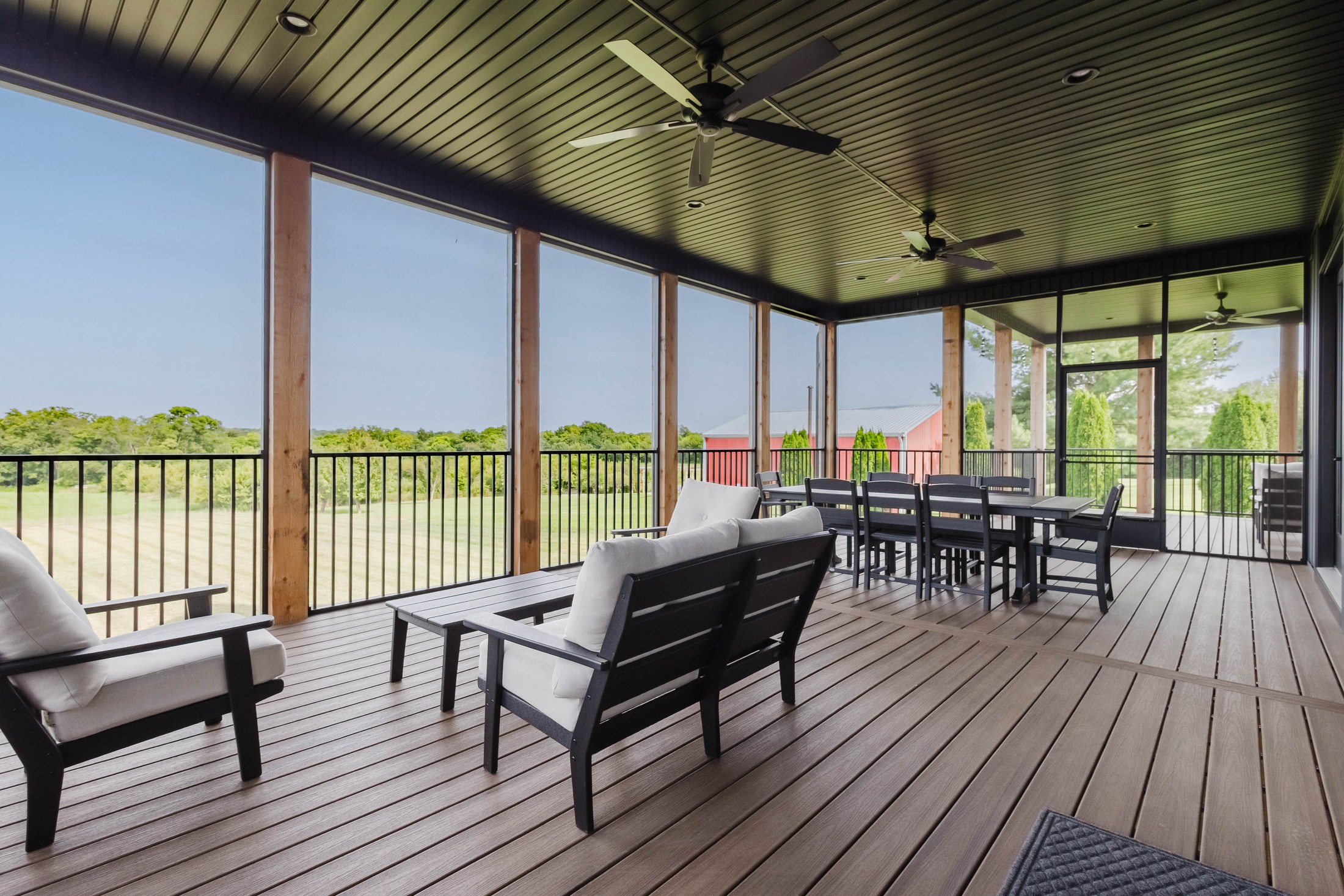 Screened porch with seating and pasture view at The Lodge